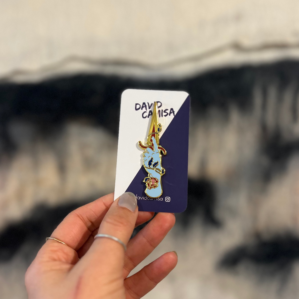 Hand holding a small card with a design on a blurred background