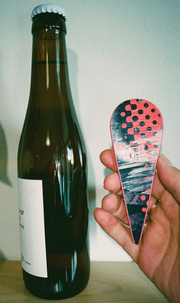 Bottle of beer with a bottle opener featuring a colorful design.