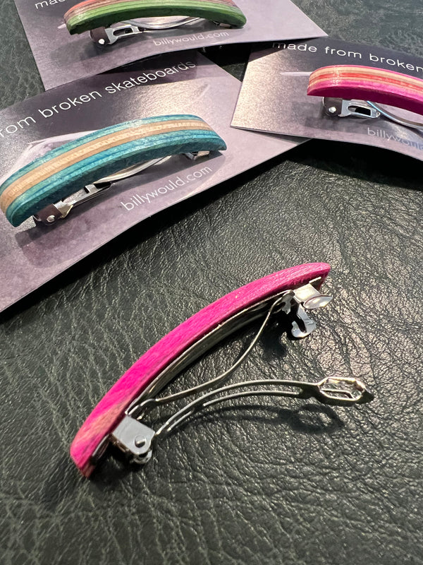 Colorful hair clips on a textured surface with 'billyward.com' branding.