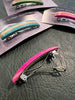 Colorful hair clips on a textured surface with 'billyward.com' branding.