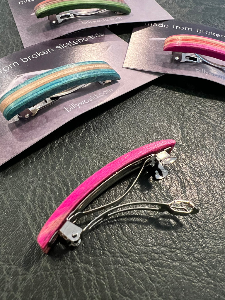 Colorful hair clips on a textured surface with 'billyward.com' branding.